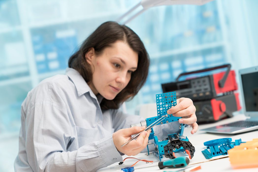 Student woman in robotics laboratory working  on project mechatr
