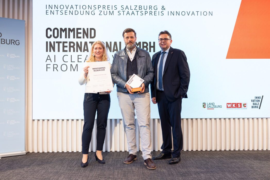 Zwei Männer und eine Frau auf der Bühne des Salzburger Innovationspreis 2026. In der Mitte hält ein Mann den Award "Innovationspreis Salzburg 2026" (Commend), links hält eine Frau eine Urkunde.