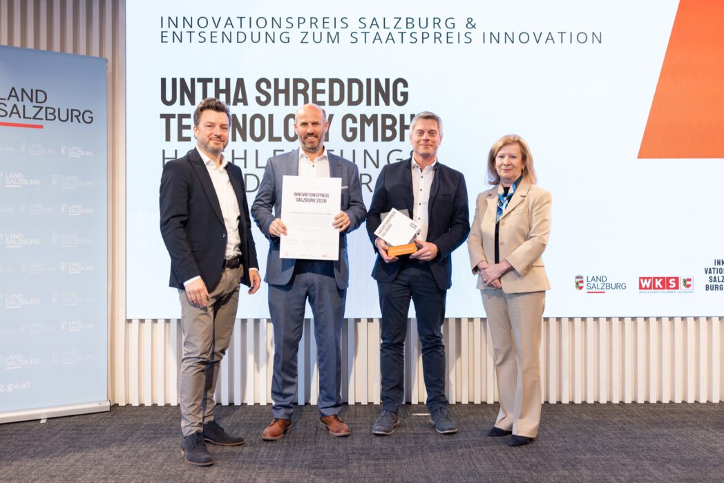 Drei Männer und eine Frau auf der Bühne des Innovationspreis Salzburg 2026. UNTHA (zwei Männer in der Mitte) wurde mit dem Preis ausgezeichnet und für den Staatspreis Innovation nominiert.