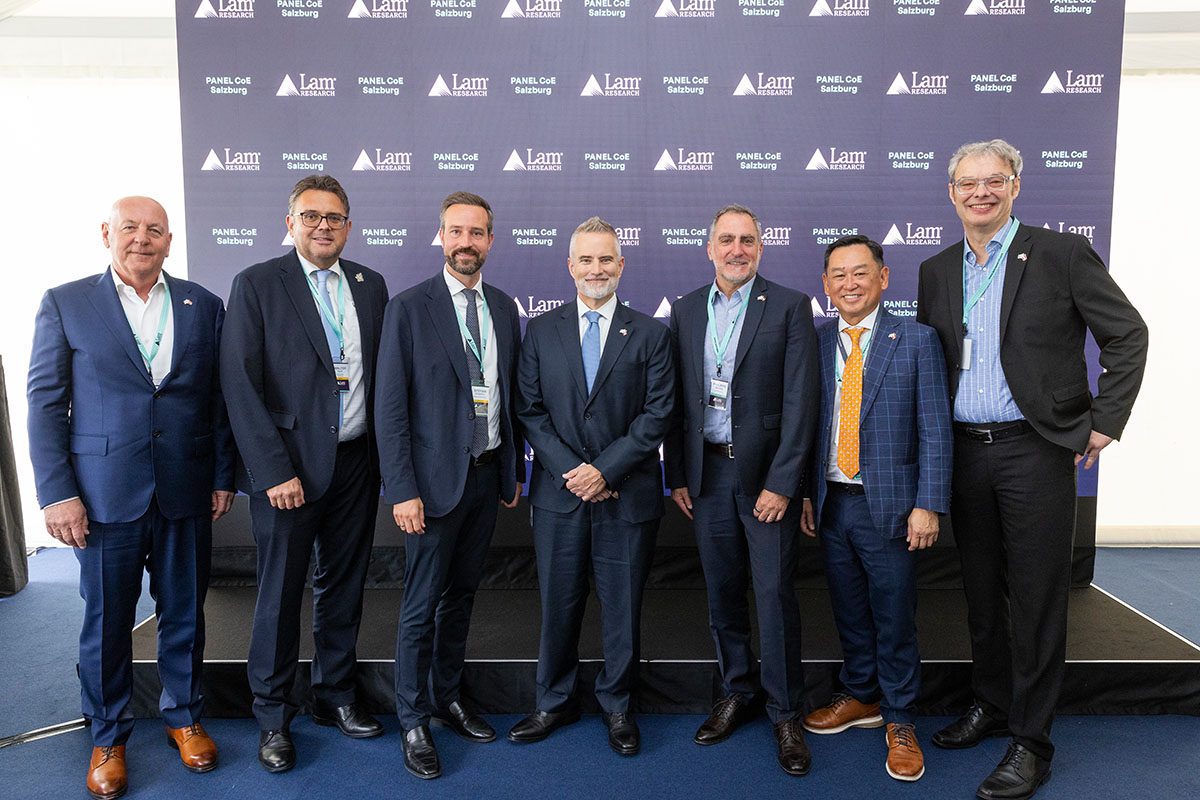 Gruppenfoto von 7 Männern bei der Eröffnung von Lam Research vor einer Logowand