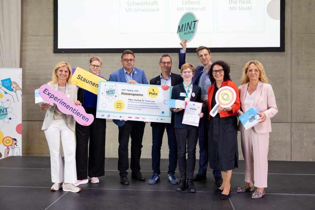 Der Sieger des ersten Platzes der MINT Challenge 2026 gemeinsam mit Vertreter:innen der Partnerorganisationen bei der Preisverleihung auf der Bühne.